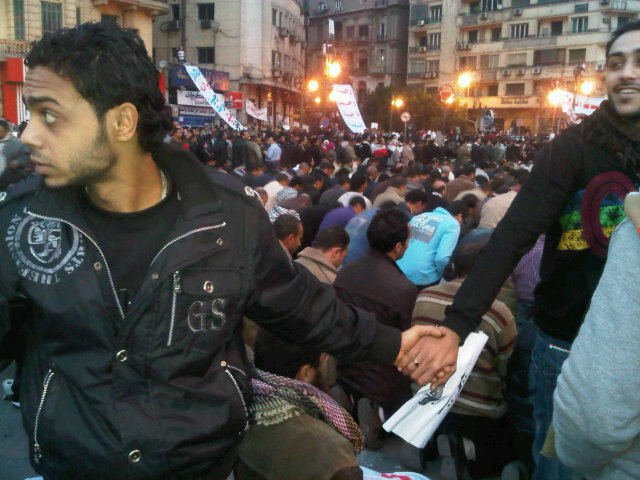 Christians protecting Muslims while they pray during protests in Egypt.
