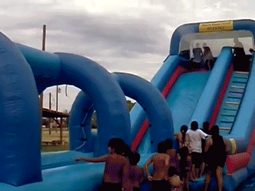 Fat man on a blow up water slide